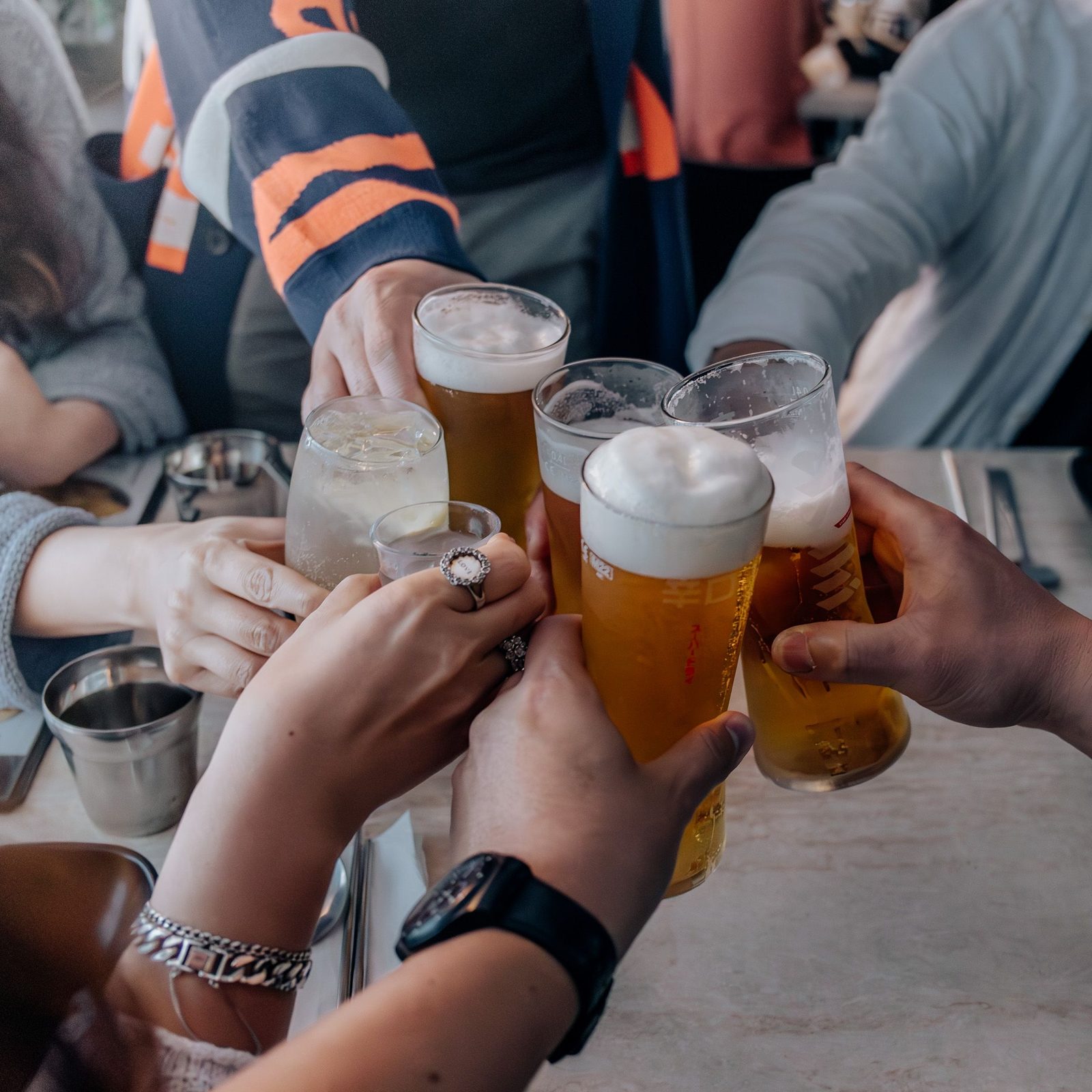 Verres levés pour un toast autour d'une table.